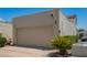 Exterior shot of attached garage with neutral paint, driveway, and desert landscaping on a sunny day at 2107 W Lane Ave, Phoenix, AZ 85021