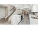 Open kitchen with stainless steel appliances, white cabinetry, and modern island adjacent to staircase and living room at 2107 W Lane Ave, Phoenix, AZ 85021