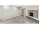 Open living room with neutral walls, sliding glass door, fireplace, and stylish, light, wood-look floors at 2107 W Lane Ave, Phoenix, AZ 85021