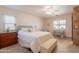Inviting bedroom with a plush bed, wood floors, bright windows, and elegant furniture, ensuring a serene retreat at 21311 N Shelby Ct, Maricopa, AZ 85138