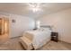 This bedroom features a ceiling fan, bench, stylish tile floors, and a luxurious queen-sized bed at 21311 N Shelby Ct, Maricopa, AZ 85138