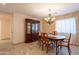 Elegant dining room featuring a classic chandelier, ample seating, and decorative china cabinet, great for gatherings at 21311 N Shelby Ct, Maricopa, AZ 85138