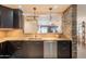 Kitchen featuring dark cabinets, stainless steel appliances and a pass-through viewing area to the living room at 21311 N Shelby Ct, Maricopa, AZ 85138