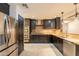 Stylish kitchen featuring stainless steel appliances, dark wood cabinets, and granite countertops at 21311 N Shelby Ct, Maricopa, AZ 85138