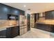 Modern kitchen boasts stainless steel appliances, granite countertops, and stylish dark cabinetry for a sleek look at 21311 N Shelby Ct, Maricopa, AZ 85138