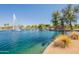 Scenic lake view featuring a fountain, park, and lush greenery in a vibrant community at 21311 N Shelby Ct, Maricopa, AZ 85138