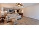 Comfortable living room featuring a plush sofa, tile floors, and a view into the connected kitchen and dining spaces at 21311 N Shelby Ct, Maricopa, AZ 85138