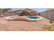 A backyard features a pool surrounded by a low-maintenance desert landscape, perfect for relaxing outdoors at 21311 N Shelby Ct, Maricopa, AZ 85138