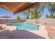 Beautiful backyard pool featuring a waterfall, shade, and privacy fence at 21311 N Shelby Ct, Maricopa, AZ 85138