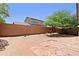 This backyard features a block fence, desert landscaping, and mature trees at 2333 W Alta Vista Rd, Phoenix, AZ 85041