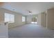 Spacious carpeted living room with ceiling fan, bright windows and access to backyard patio at 2333 W Alta Vista Rd, Phoenix, AZ 85041