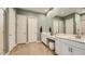 Bright bathroom featuring double sinks, white cabinetry, a large mirror, and wood-look flooring at 2955 E Lucky Horseshoe Ln, San Tan Valley, AZ 85140