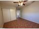 Cozy bedroom with tile floors, a ceiling fan, and a closet for ample storage at 324 E Riviera Dr, Tempe, AZ 85282