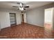 View of an empty bedroom with tiled floors, a ceiling fan, an open closet and access to the bathroom at 324 E Riviera Dr, Tempe, AZ 85282