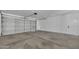 A spacious two-car garage featuring sealed concrete floors, bright lighting, and a side entry door at 3926 E Coconino St, Phoenix, AZ 85044