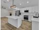 Bright kitchen featuring white cabinets, stainless appliances, quartz counters, and modern lighting at 3926 E Coconino St, Phoenix, AZ 85044