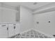 A well-lit laundry room features stylish flooring, modern cabinets, and floating shelves for storage at 3926 E Coconino St, Phoenix, AZ 85044