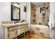 Bright bathroom featuring decorative vanity, tiled walls, and a bathtub with shower at 40039 N 107Th Pl, Scottsdale, AZ 85262