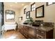 Bright bathroom featuring a clawfoot tub, double sinks, granite countertops, and rustic cabinetry at 40039 N 107Th Pl, Scottsdale, AZ 85262