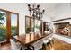 Elegant dining room with a large table, fireplace, and doors to the outdoor view at 40039 N 107Th Pl, Scottsdale, AZ 85262