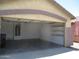 Spacious garage featuring built-in shelves and a door to the outside at 46129 W Barbara Ln, Maricopa, AZ 85139