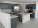 Well-lit kitchen featuring stainless steel appliances, grey cabinets, and a center island at 46129 W Barbara Ln, Maricopa, AZ 85139
