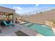 Amazing backyard featuring a pool with a stacked stone waterfall, an outdoor fireplace, and comfortable lounge furniture at 6106 W Spur Dr, Phoenix, AZ 85083