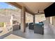 Covered patio space with a fireplace, plush seating and a view of the pool and desert landscape at 6106 W Spur Dr, Phoenix, AZ 85083