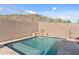 Beautiful in-ground pool with a tanning ledge and a stacked stone waterfall feature, perfect for relaxation at 6106 W Spur Dr, Phoenix, AZ 85083