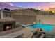 Beautiful pool and fireplace area with lush landscaping, and a water feature provides a tranquil setting at 6106 W Spur Dr, Phoenix, AZ 85083
