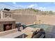 Inviting backyard pool with a stacked stone waterfall feature and a cozy fireplace with comfortable lounge seating at 6106 W Spur Dr, Phoenix, AZ 85083