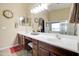 This bathroom features a double sink vanity, large mirror, and neutral tile flooring at 708 E Dry Creek Rd, San Tan Valley, AZ 85143