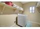 Bright laundry room with a modern washer, storage shelves and decorated with laundry themed mat at 708 E Dry Creek Rd, San Tan Valley, AZ 85143