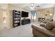 Spacious carpeted living room with two leather chairs and a large television set with lots of natural light at 708 E Dry Creek Rd, San Tan Valley, AZ 85143
