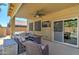 Outdoor patio with comfortable seating, ceiling fan, and TV, leading to the pool and hot tub at 708 E Dry Creek Rd, San Tan Valley, AZ 85143