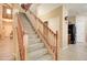 Spacious staircase with carpeted steps, wooden banisters, and lots of natural light from the foyer window at 708 E Dry Creek Rd, San Tan Valley, AZ 85143