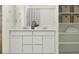 Elegant bathroom featuring double sinks, a neutral color palette, and stylish storage shelves at 9532 W Pinchot Ave, Phoenix, AZ 85037
