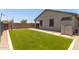 Beautiful backyard featuring a manicured lawn, patio area, and stylish exterior lighting at 9642 E Tesla Ave, Mesa, AZ 85212
