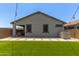A backyard featuring a lawn, patio with a covered seating area, and modern exterior design at 9642 E Tesla Ave, Mesa, AZ 85212