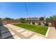 Inviting backyard showcasing an artificial lawn, stone pavers, and a wrought iron fence at 9642 E Tesla Ave, Mesa, AZ 85212