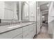 Bathroom featuring a double vanity, framed mirrors, and a doorway to another room at 9642 E Tesla Ave, Mesa, AZ 85212