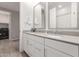 Bathroom featuring a double vanity, framed mirrors, and a separate laundry area at 9642 E Tesla Ave, Mesa, AZ 85212