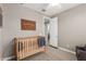 Neutral Bedroom with crib, wall decor, doorway to other rooms, and plush carpet at 9642 E Tesla Ave, Mesa, AZ 85212