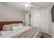 Neutral bedroom featuring a ceiling fan, closet, and comfortable bed with wood headboard at 9642 E Tesla Ave, Mesa, AZ 85212