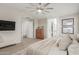 Spacious bedroom featuring a TV, bench and a glimpse of an ensuite bath and closet at 9642 E Tesla Ave, Mesa, AZ 85212