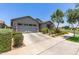 Charming single-story home featuring a two car garage and desert landscaping in the front yard at 9642 E Tesla Ave, Mesa, AZ 85212