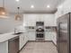 Modern kitchen showcasing stainless steel appliances, white cabinets, and a stylish woven light fixture at 9642 E Tesla Ave, Mesa, AZ 85212