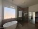 Elegant bathroom with freestanding tub, glass shower, and window views at 11006 S Indian Wells Dr, Goodyear, AZ 85338