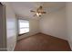 Neutral carpeted bedroom with a ceiling fan and a window providing natural light at 1381 E Prickly Pear Dr, Casa Grande, AZ 85122