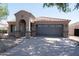 Inviting front exterior featuring a tile roof, a two-car garage, and an arched entryway at 1381 E Prickly Pear Dr, Casa Grande, AZ 85122